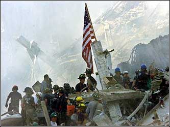 Rescuers working under the American flag. (cbs)